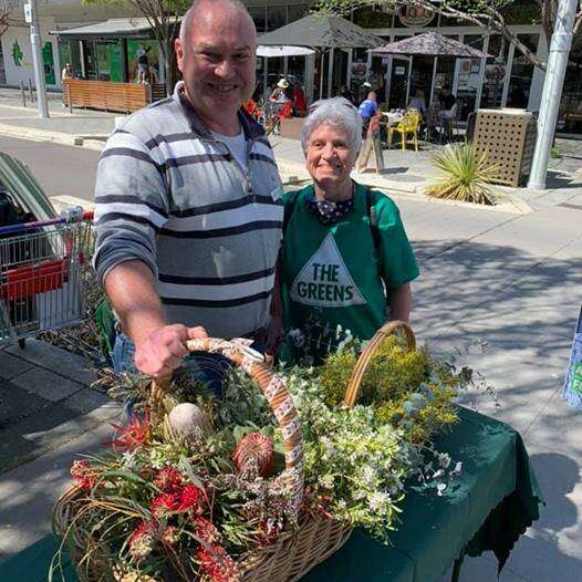 Andrew Braddock handing out flowers on the campaign trail. Picture: Supplied