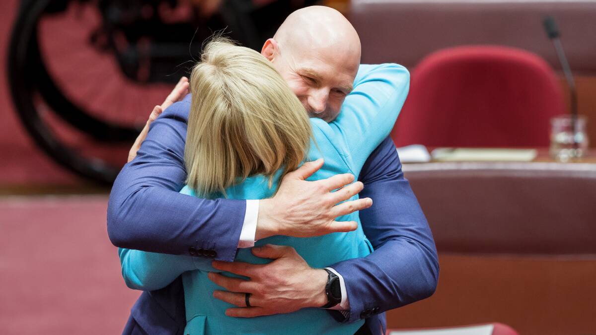 ACT senators David Pocock and Katy Gallagher embrace after the final vote. Picture by Sitthixay Ditthavong