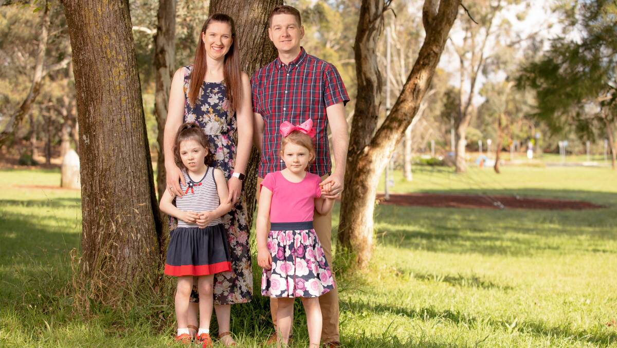 Belinda and Hugh Clifford with their daughters Ashley, 7, and Sophie, 5. The family is appealing to the NDIS to reverse a cut to Ashley's funding. Picture: Sitthixay Ditthavong