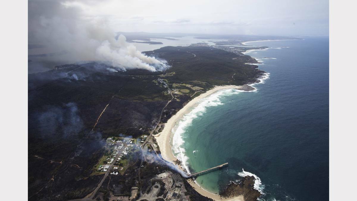 Scenes from the fires at Catherine Hill Bay and Chain Valley Bay on Friday. Photo by James Brickwood