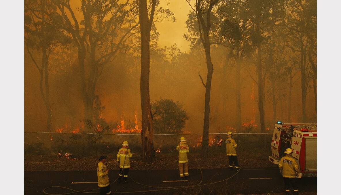 Fire crews working on this fire near Lake Road, Elermore, as flames approach Elermore Geln housing estate. Photo: Max Mason-Hubers, Newcastle Herald.