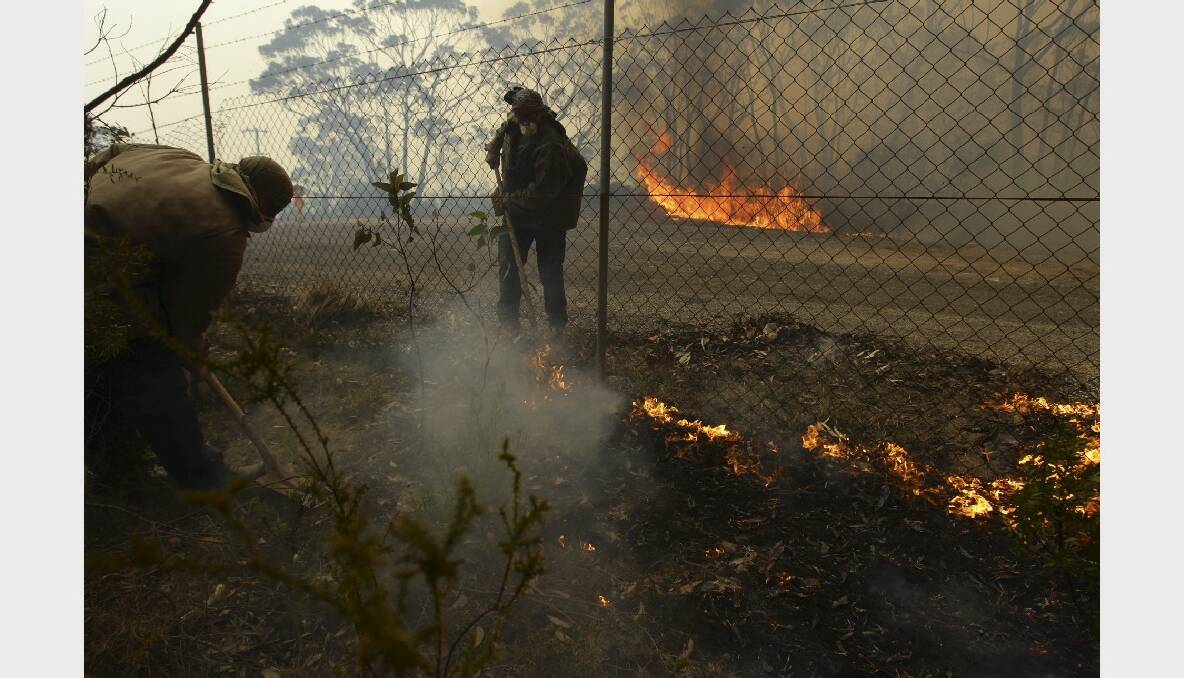 Residents protect their property as an out of control bushfire threatens four homes near Newnes train station. Photo: Wolter Peeters.