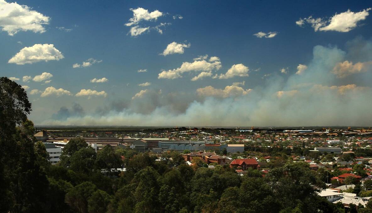 Looking from Braye Park Waratah across to a skyline of large plumes of smoke from a fire at Heatherbrae. Photo: Simone de Peak, Newcastle Herald.