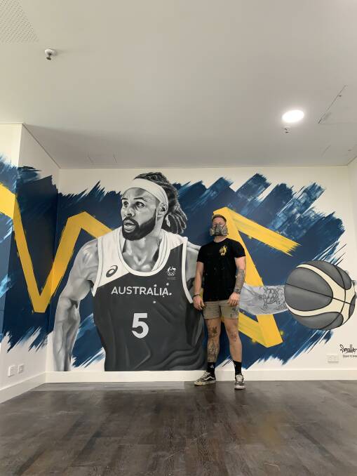 Artist Smalls with the completed work. Picture: Supplied